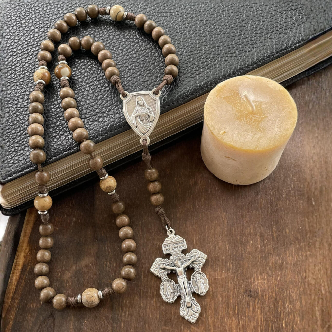 A handmade Seven Sorrows Rosary made from paracord with a silver Pardon Crucifix and silver Immaculate Heart of Mary centerpiece and the Hail Mary beads are grey brown wood and the Our Father beads are brown stone.